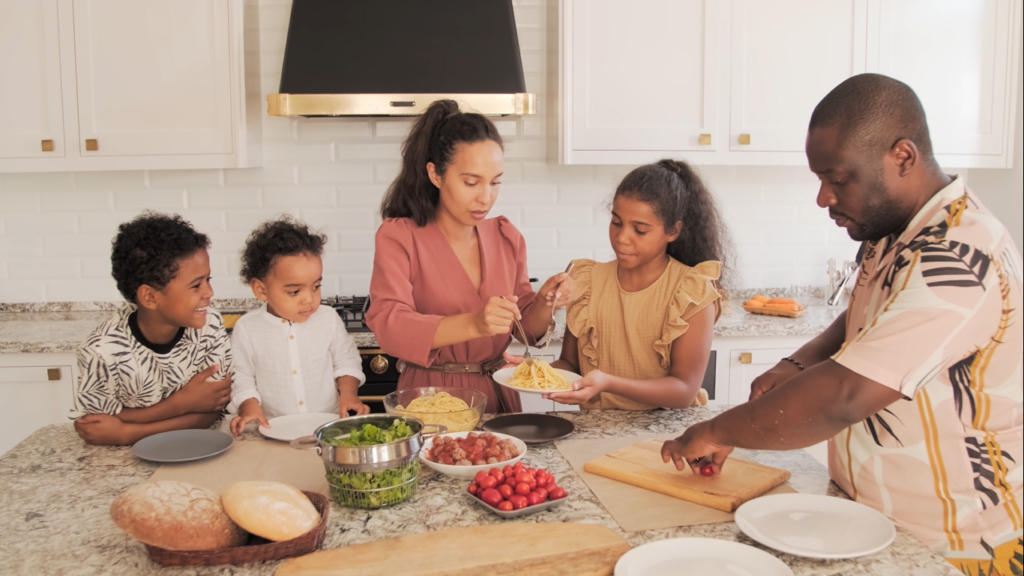 Everyone Blames China... But India Just Took 1 in 3 New Cars in Mzansi A mother and father preparing lunch for their children in a warm kitchen, representing the real families impacted by job losses in the automotive sector